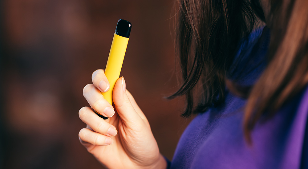 Young person holding a disposable vape